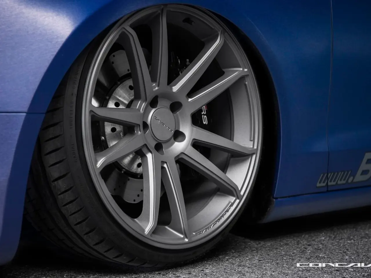 Here I can see a wheel of a car which is in blue color on the road. On the right bottom of the...