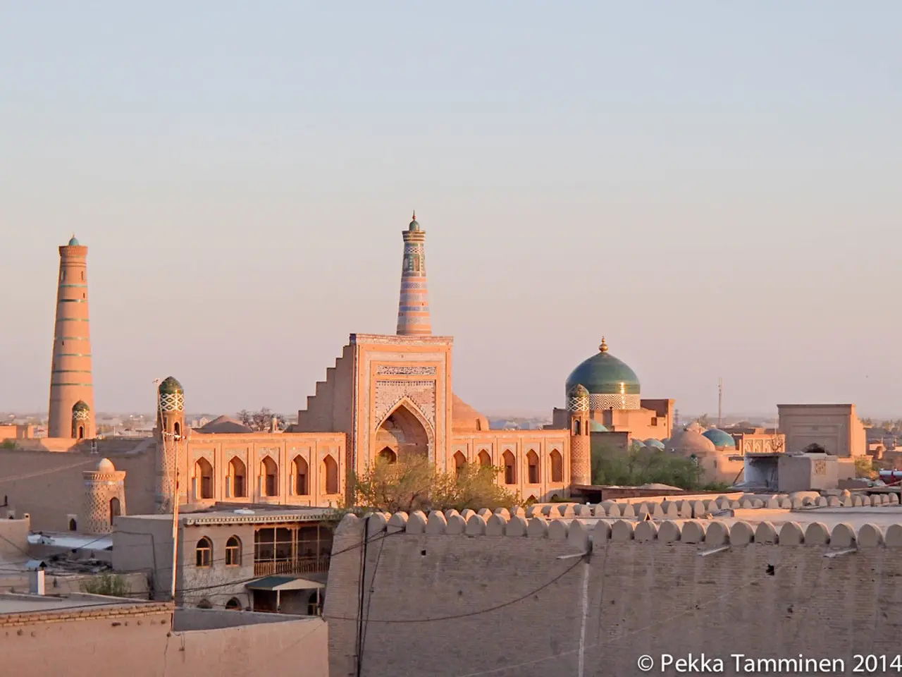 In this image I can see number of buildings, trees, wires and here I can see watermark.