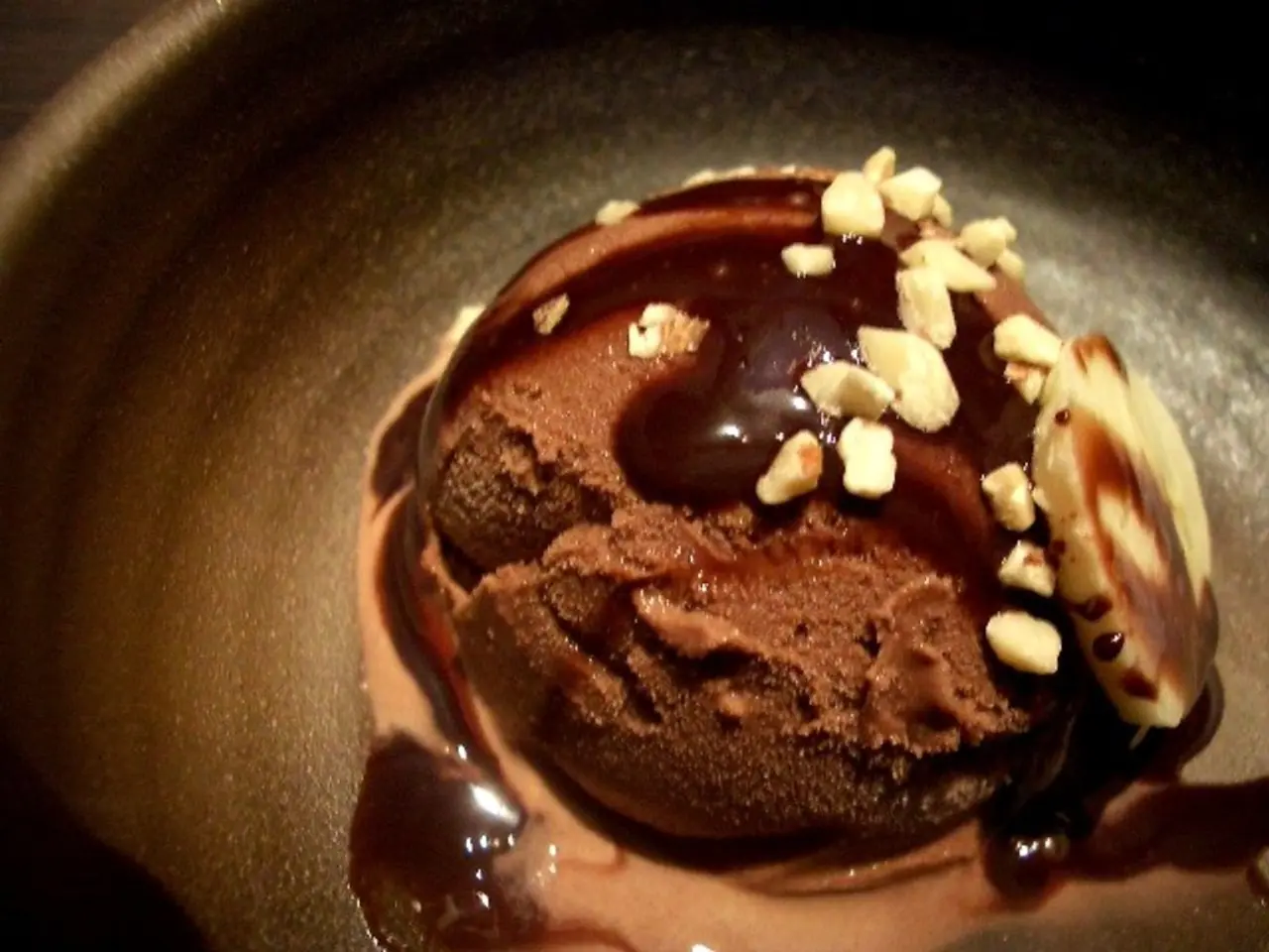 In this picture I can see the chocolate dessert in a black plate.