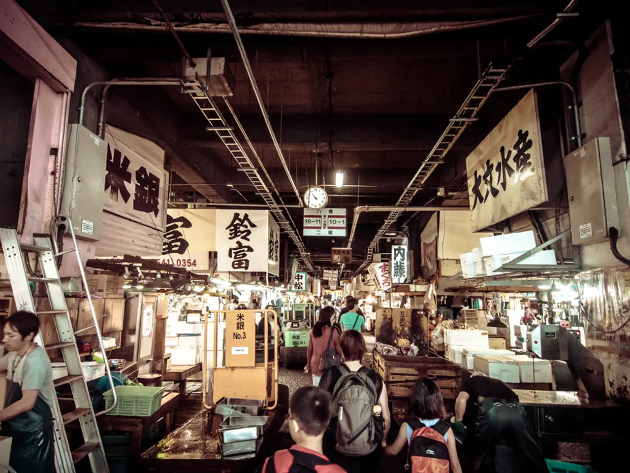 In the center of the image there are persons walking on the road. On the right side of the image we...