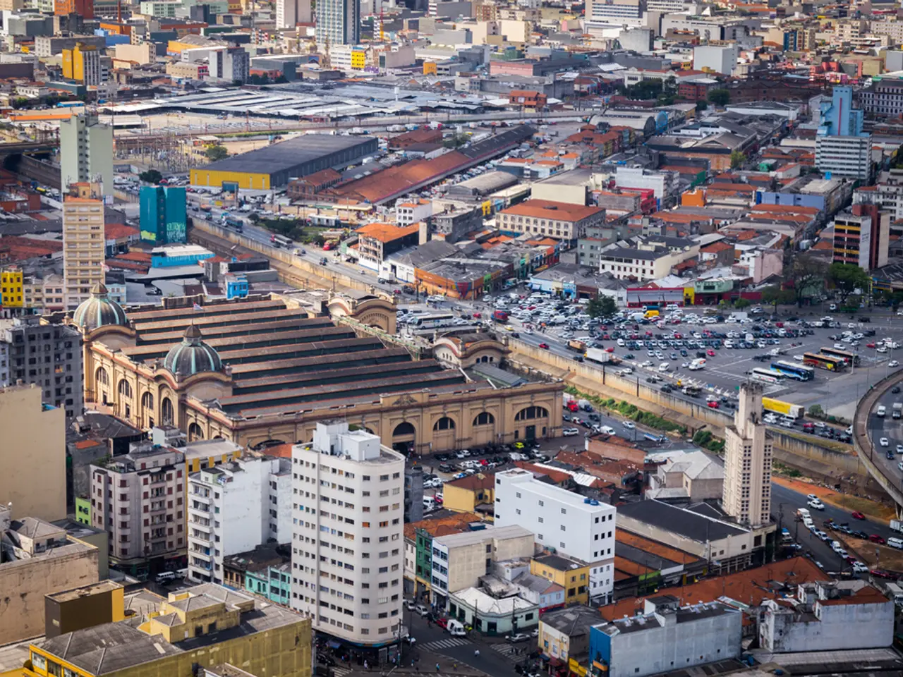 In this image, we can see so many buildings, houses, trees, vehicles, roads and bridges.