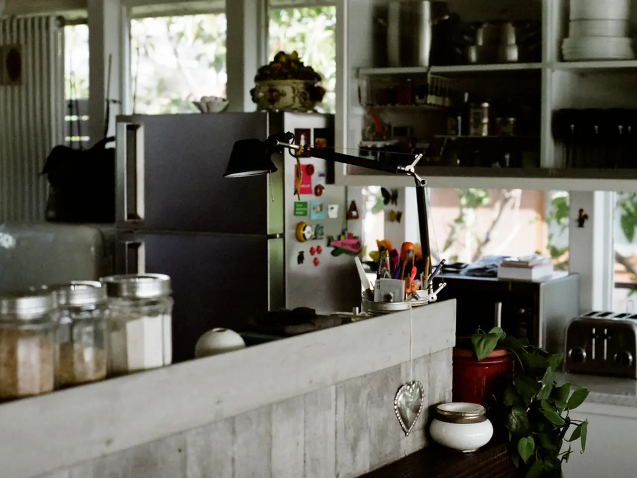 On the left side there are many bottles. Also there is a wall. Near to that there is a pot. And...