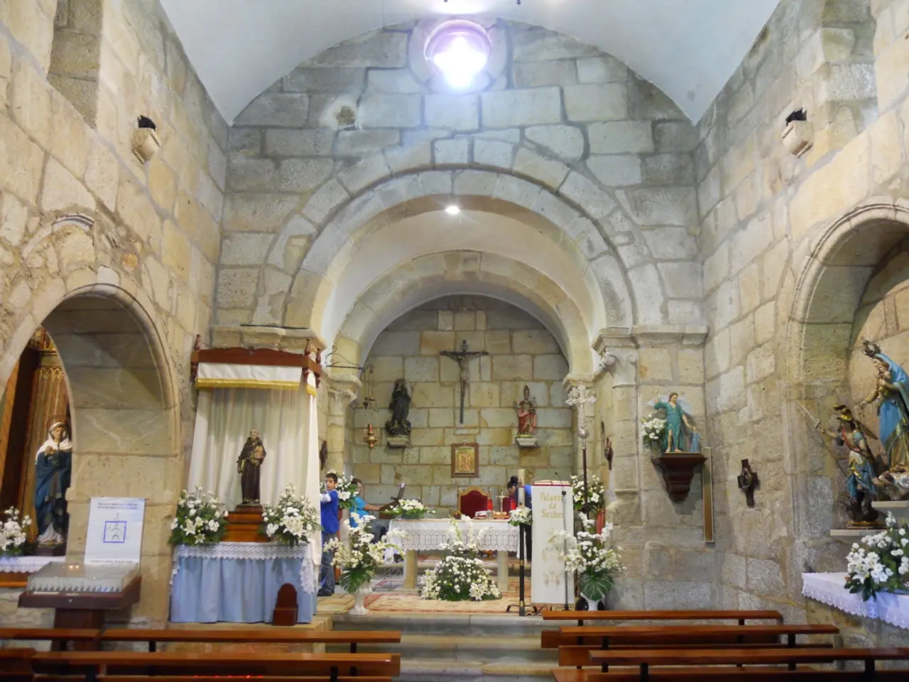 It seems like the picture is captured inside the church, there are many sculptures, flower plants...