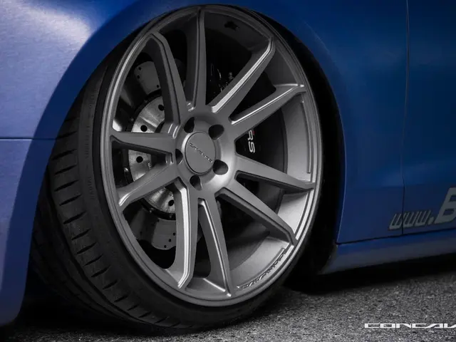 Here I can see a wheel of a car which is in blue color on the road. On the right bottom of the...