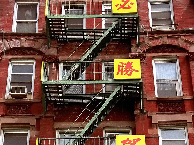 There is a building and it has a lot of windows and doors and in front of the door there are stairs...