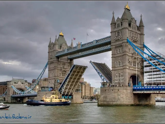 In this image I can see few buildings, windows, bridge, sky and few ships on the water surface.