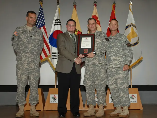 In the picture we can see four men are standing on the stage three are in army uniform and one man...