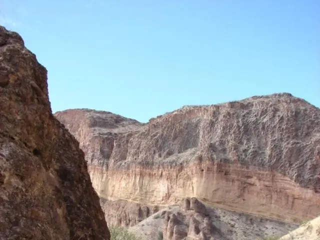 In this image I can see trees, mountains and the sky. This image is taken may be during a day.
